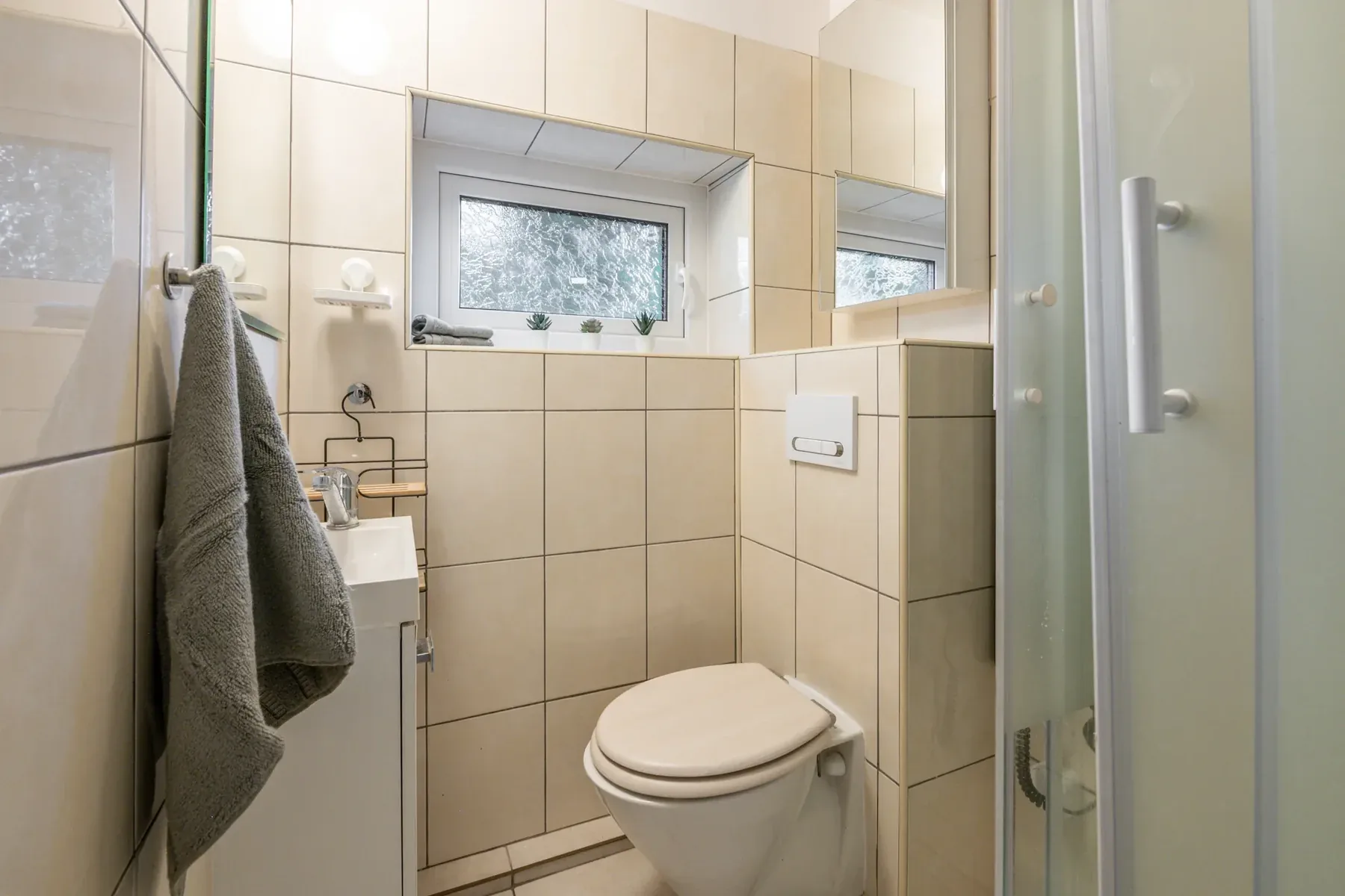 Jasna łazienka po remoncie z kompaktową kabiną prysznicową